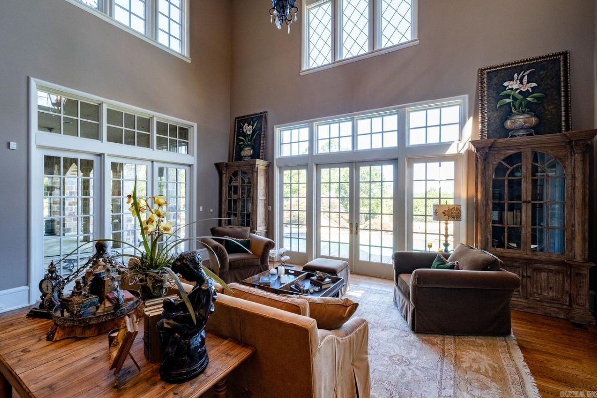 A living room with windows, a rug, cabinets, couches, and a center table.
