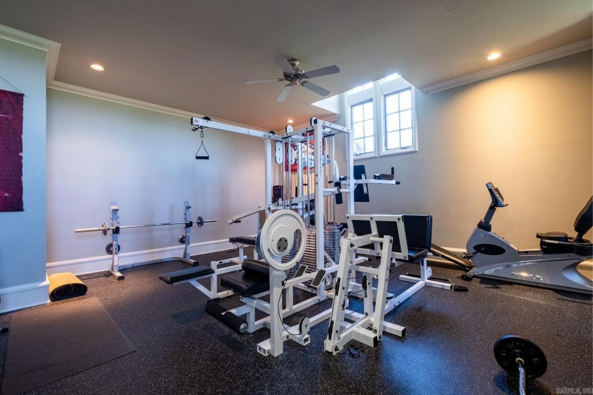 A home gym with a ceiling fan and gym equipment.