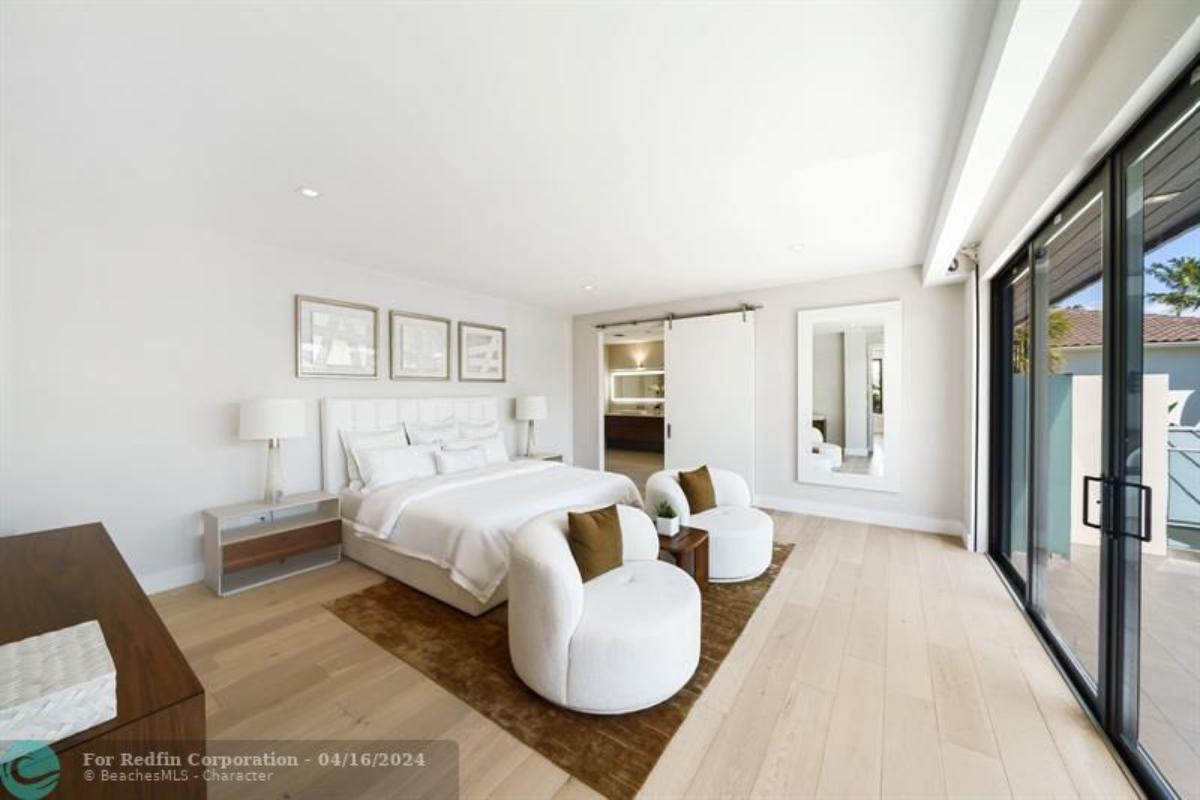 Bedroom with wood flooring and sliding glass door.