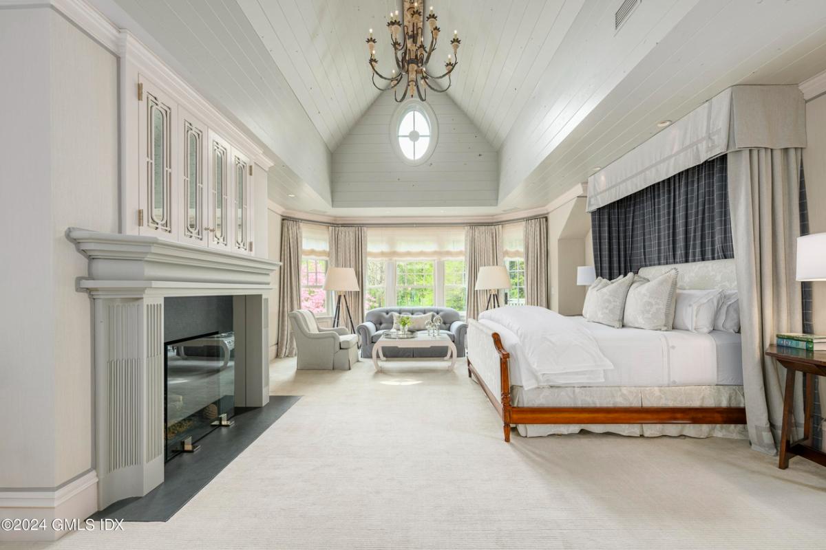 Bedroom with carpet flooring and a fireplace.