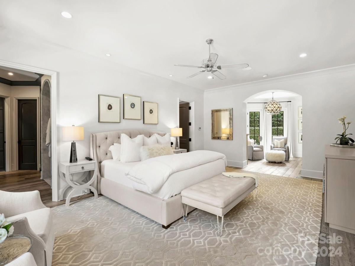 Bedroom with hardwood floors and its own living space.