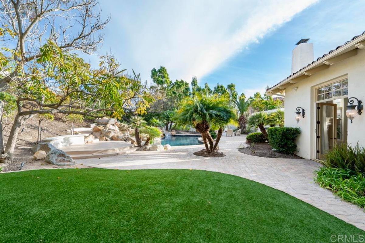 Backyard with a pool and a large lawn.