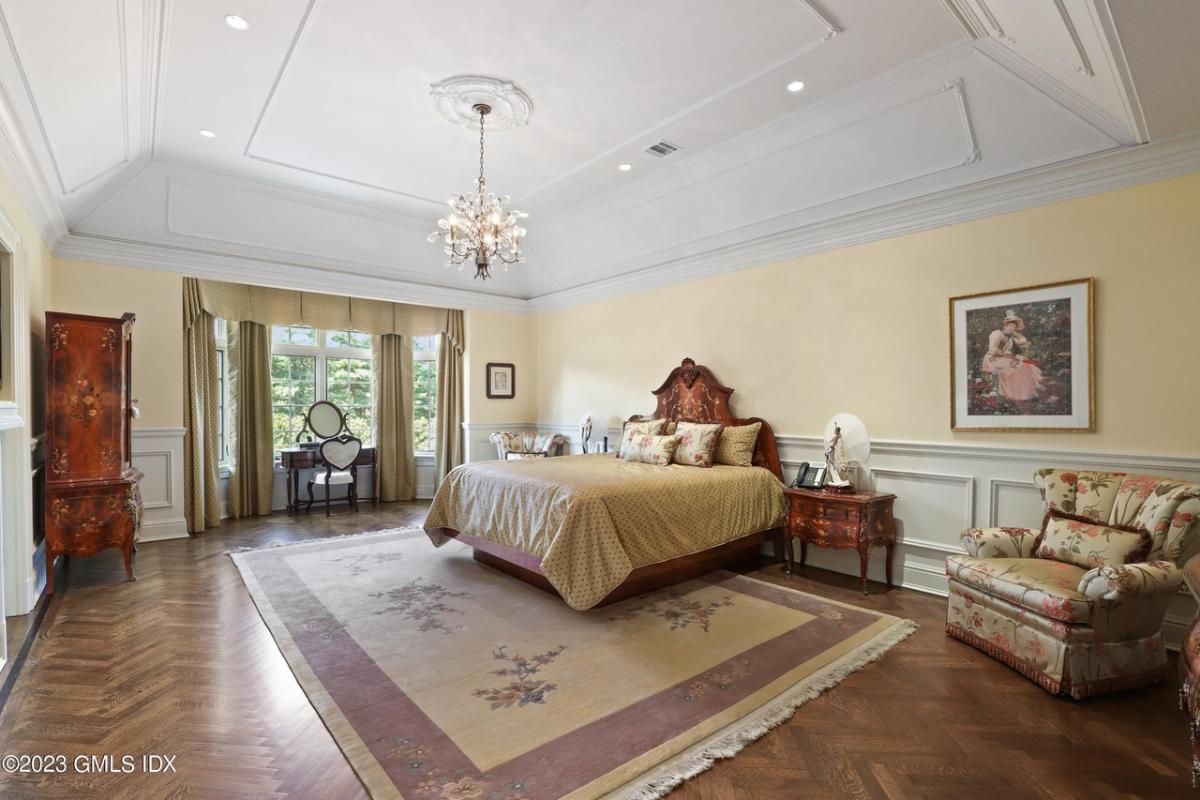Bedroom with hardwood floors, chandelier and glass windows.