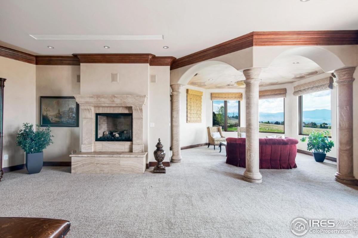 Family room with chairs, sofa, carpet flooring and a fireplace.