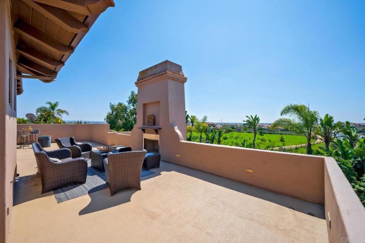 Patio with a table, chairs and a fireplace.