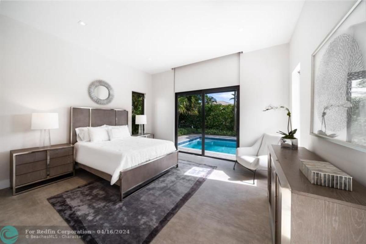 Bedroom with wood flooring and sliding glass door.