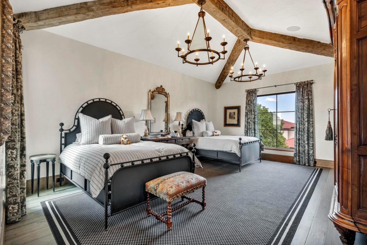 Bedroom with two beds, hardwood floors and glass windows.