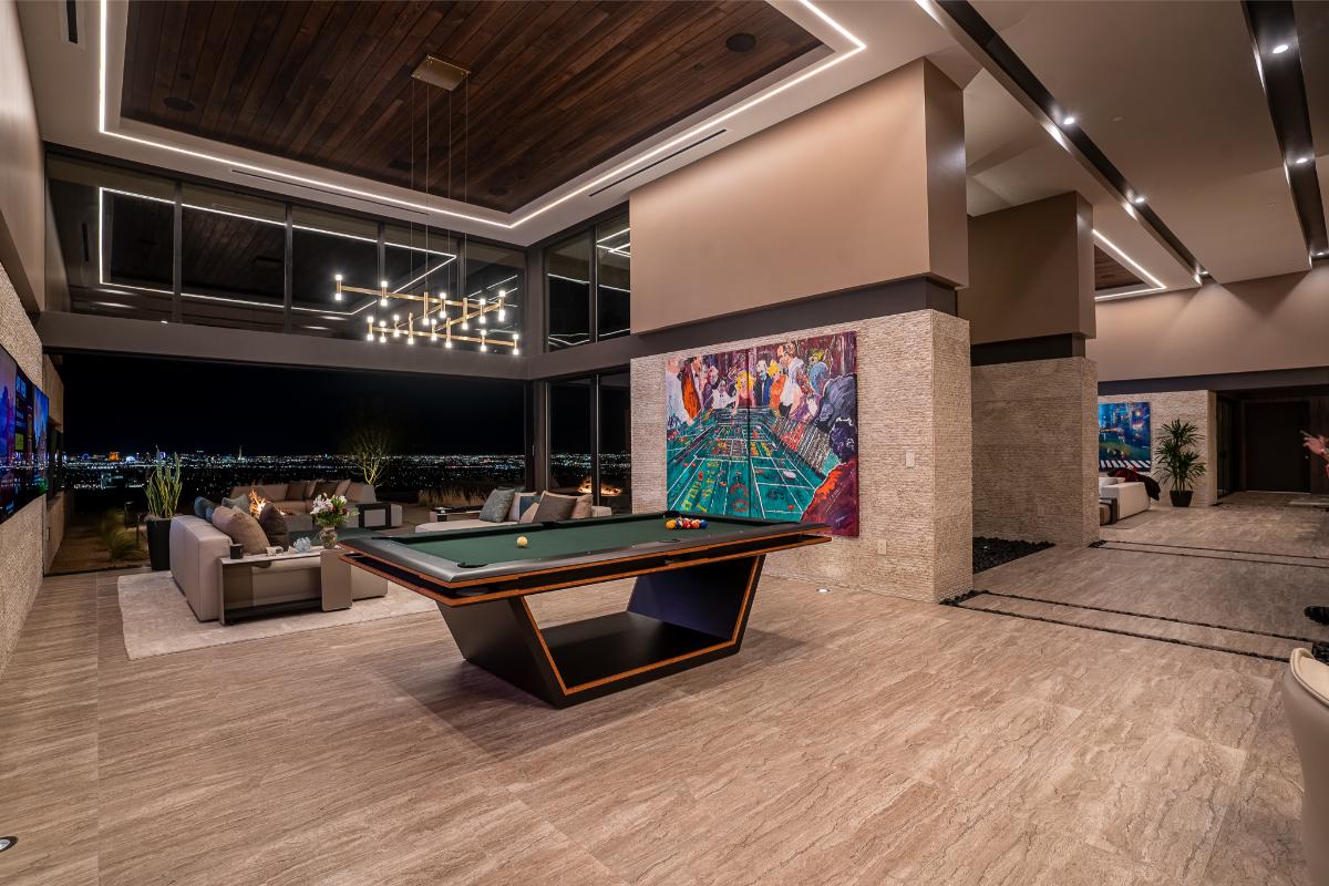 Recreational room with couches, billiards table and a view of the city.