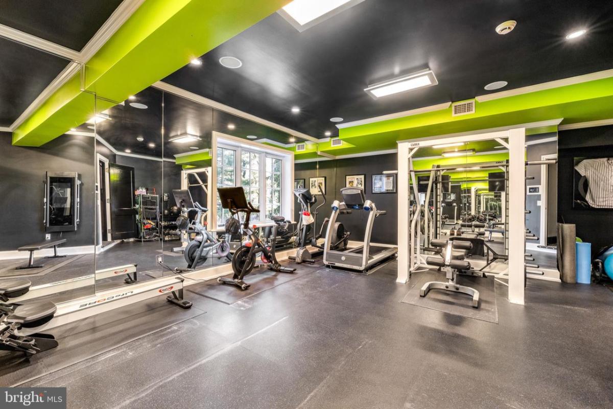 Home gym with a large mirror and workout equipment.
