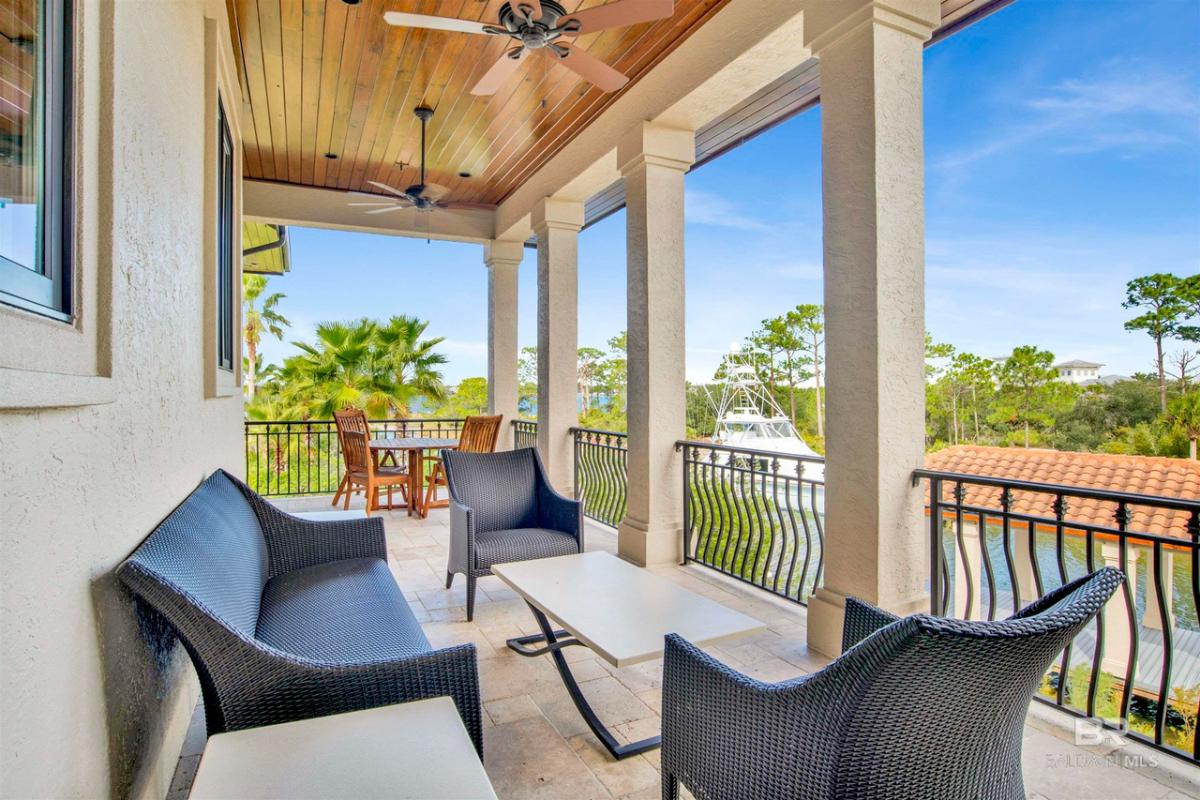 Balcony with tables, chairs and metal railings.