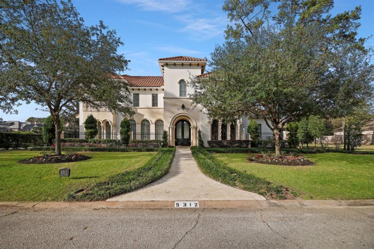 Front view of the mansion with a large lawn.