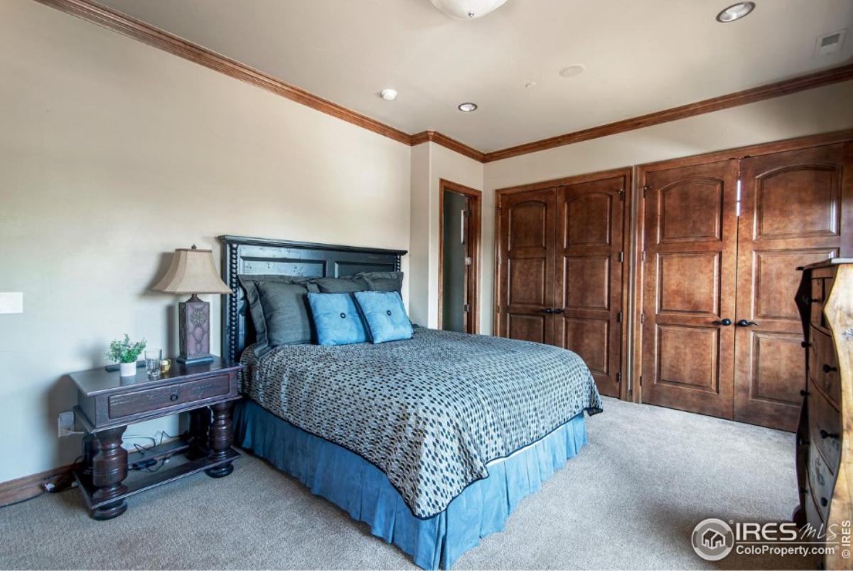 Bedroom with a large bed and carpet flooring.