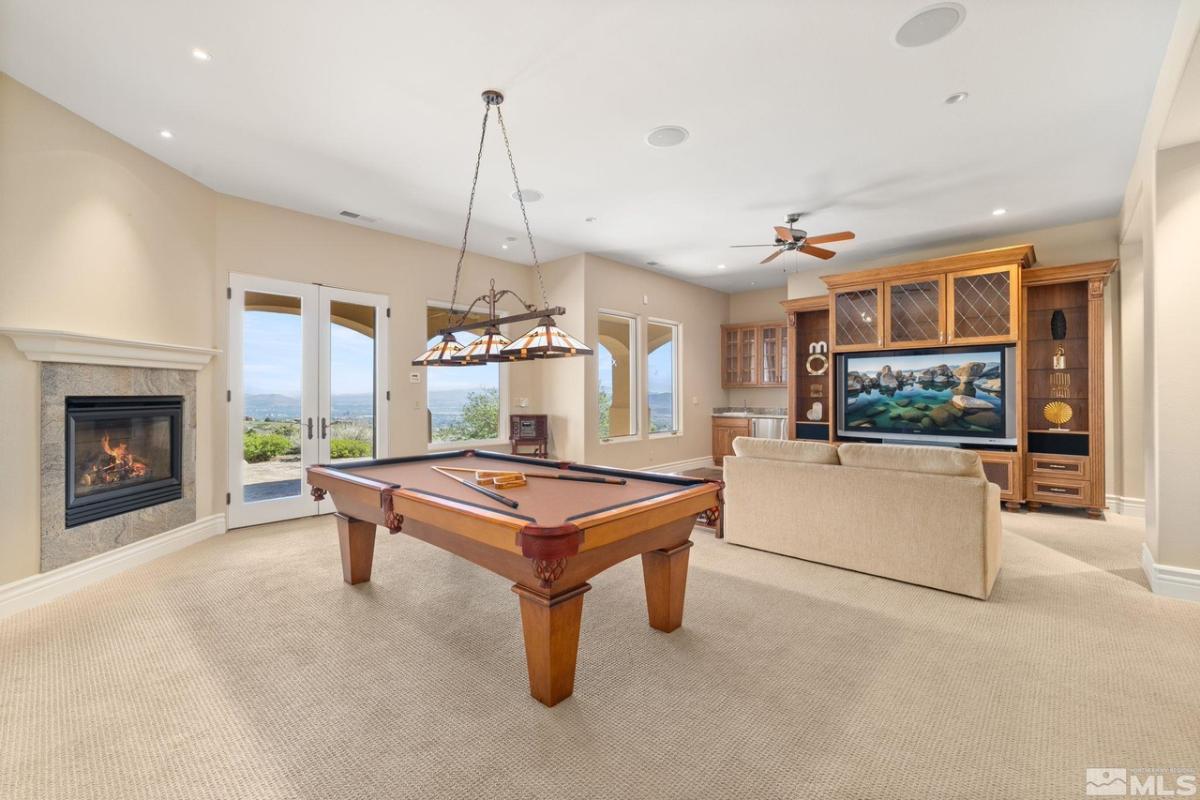 Recreational room with a TV, sofa and billiards table.