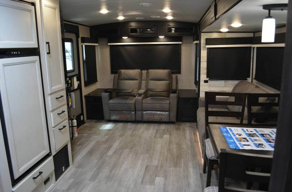 Living space with theater seats and a vinyl floor.