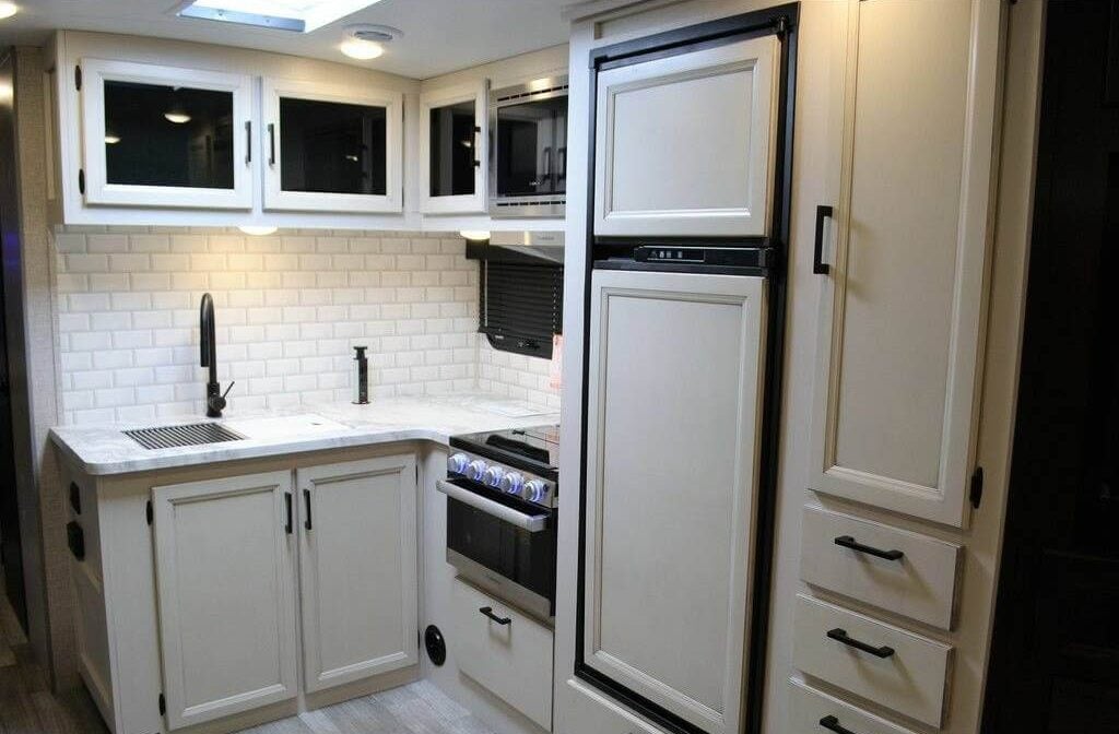 Kitchen with white cabinets, marble counters, and modern appliances.