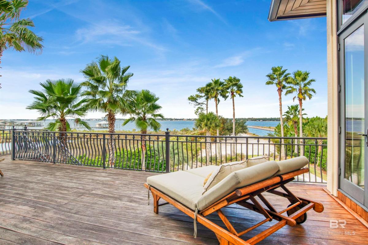 Balcony with lounge chairs and metal railings.