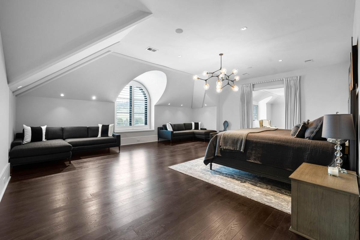 Bedroom with hardwood floors and a living space.
