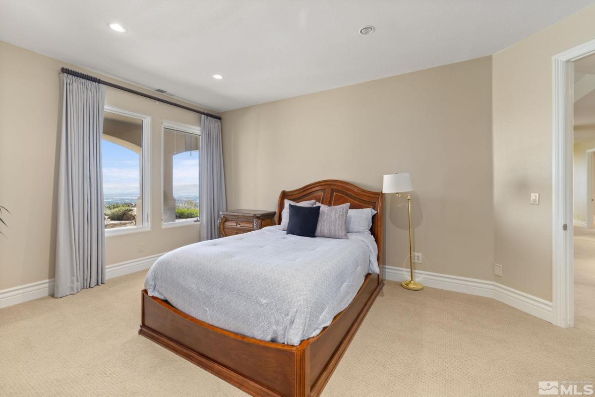 Bedroom with carpet floors and glass windows.