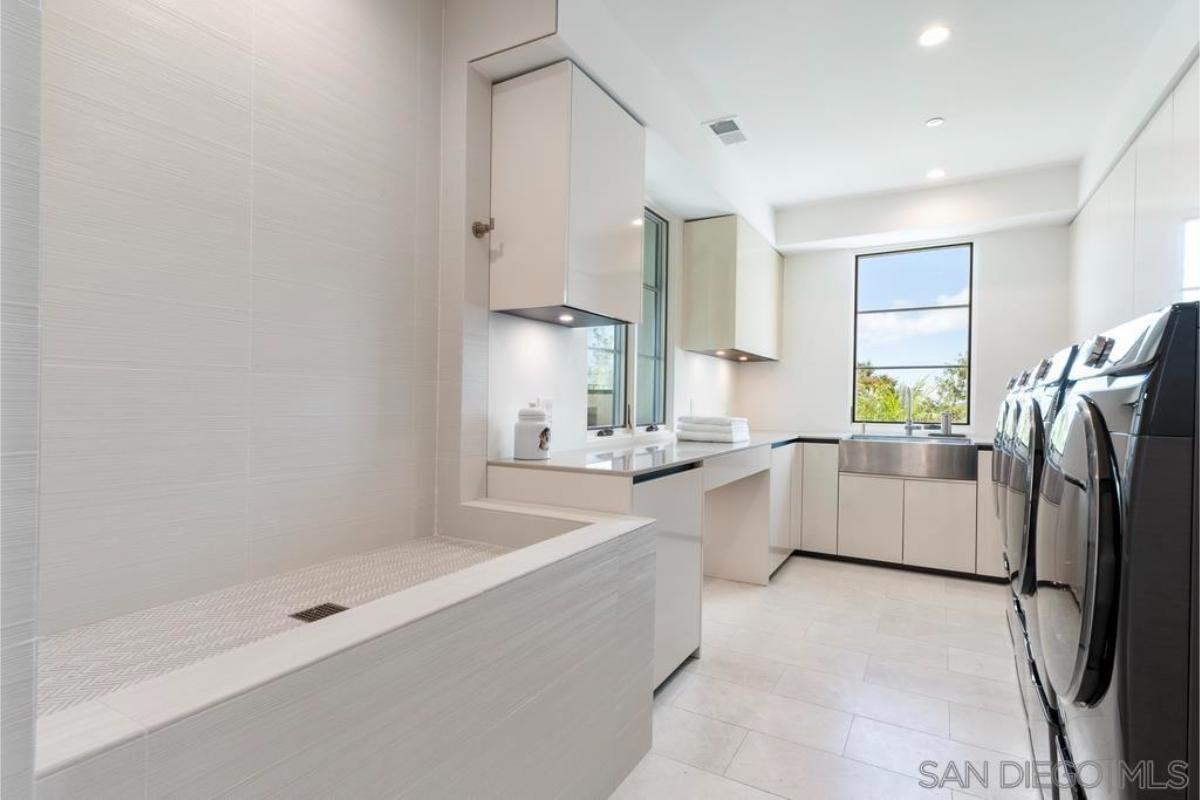 Laundry room with a sink and cabinets.