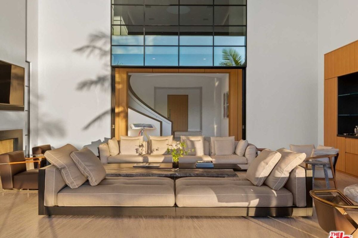 A living room with a TV, couches, chairs, and a center table.