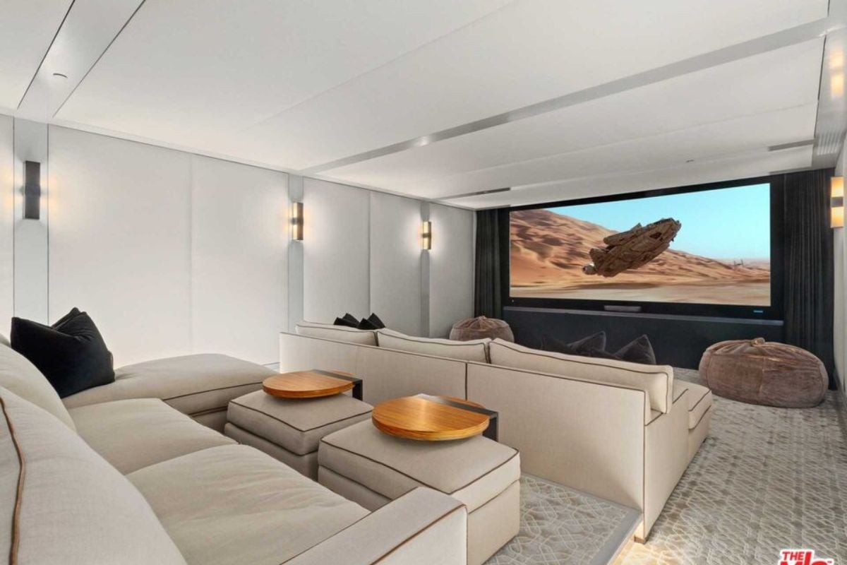 A home theater with white ceiling, walls, couches, and a large screen.
