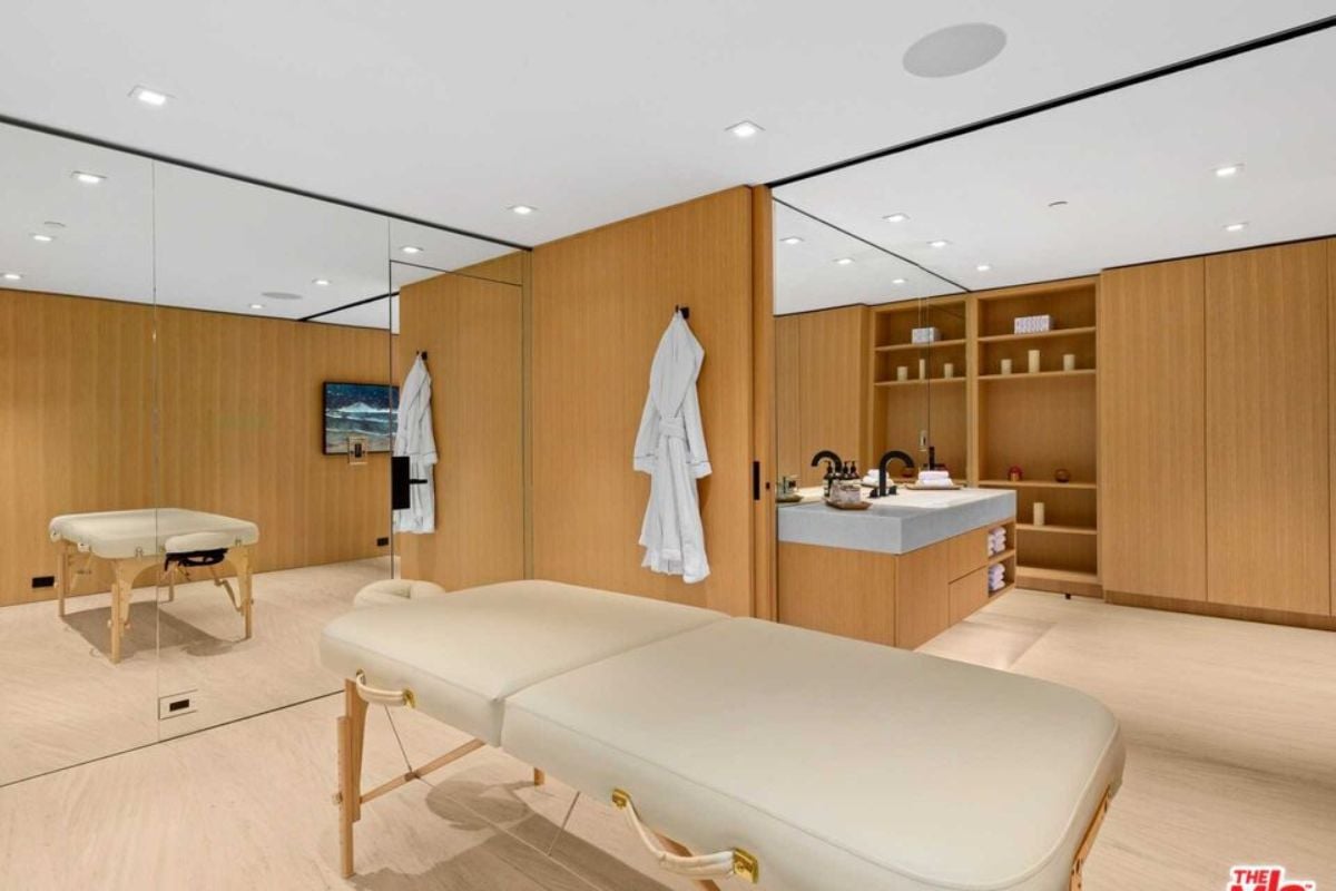 A massage room with a mirror and a massage table.
