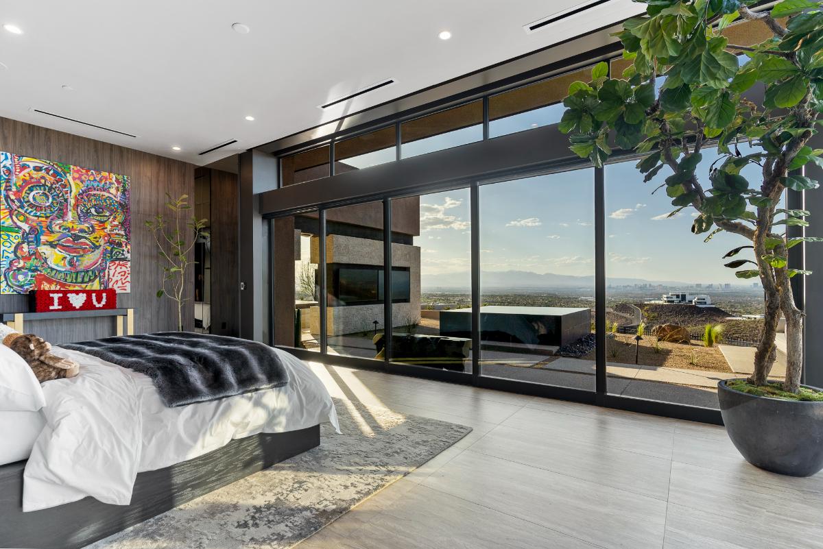 Bedroom with a large bed and glass walls.