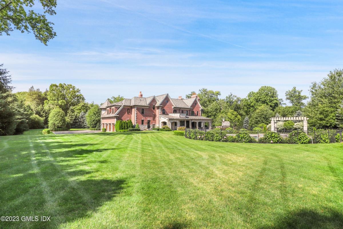 Distant view of the mansion with lush gardens and sweeping lawns.