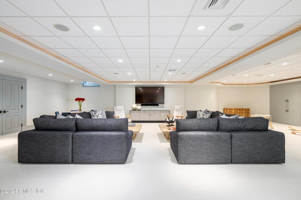 Media room with a TV and a sofas.
