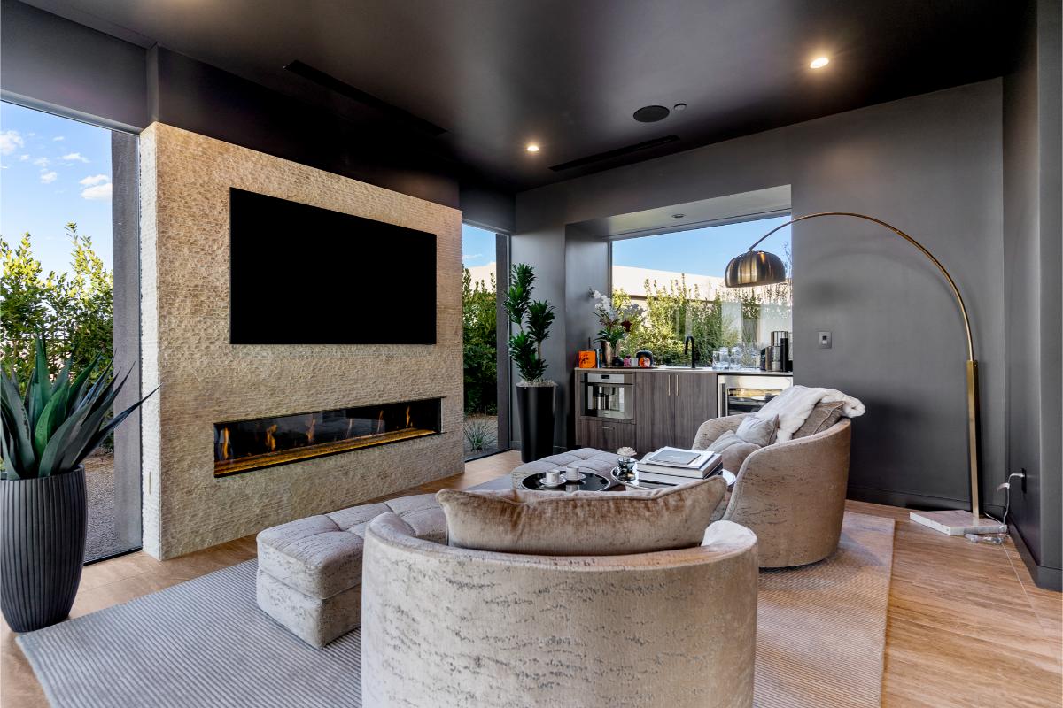 Outdoor living space with a fireplace and a bar.