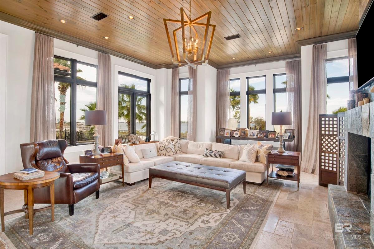Living room with table, chairs, chandelier and glass windows.