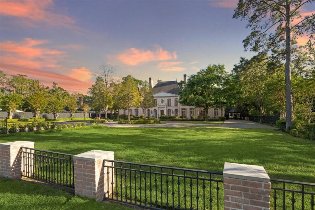 Distant view of the mansion with a large green lawn.