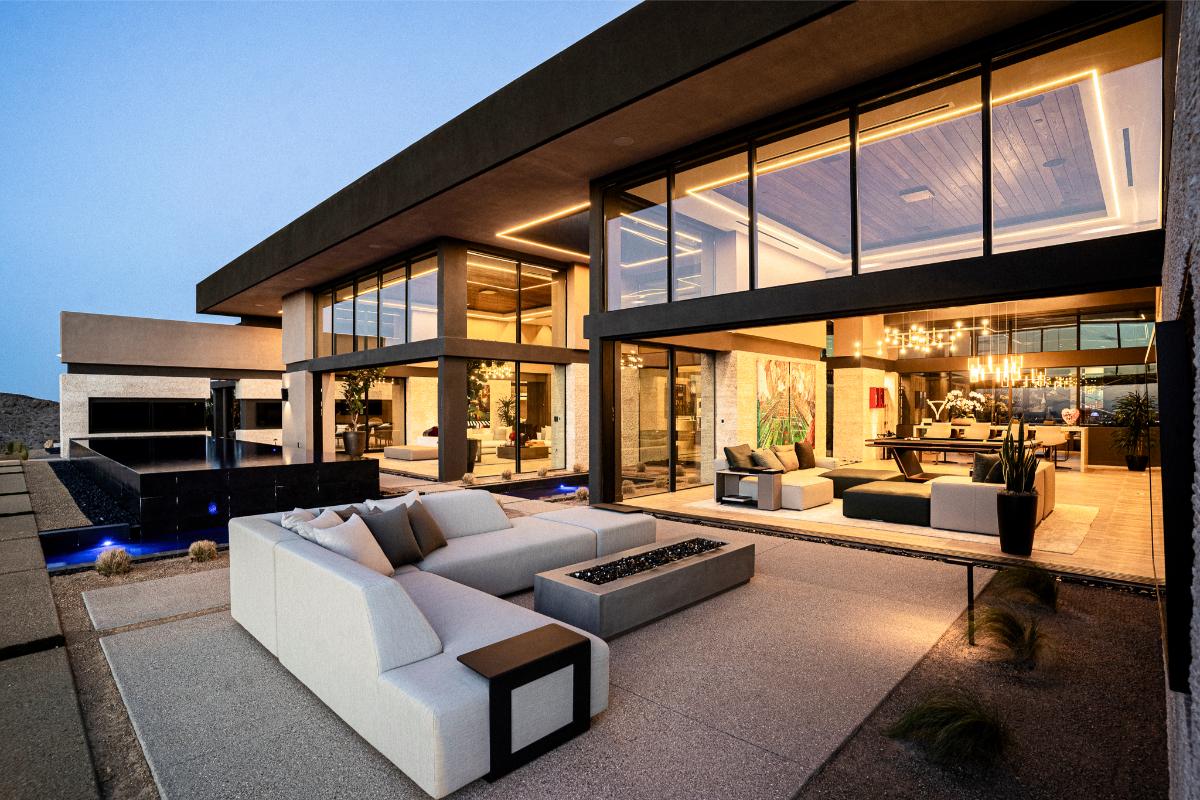 Backyard of the mansion with a pool and a fire pit.