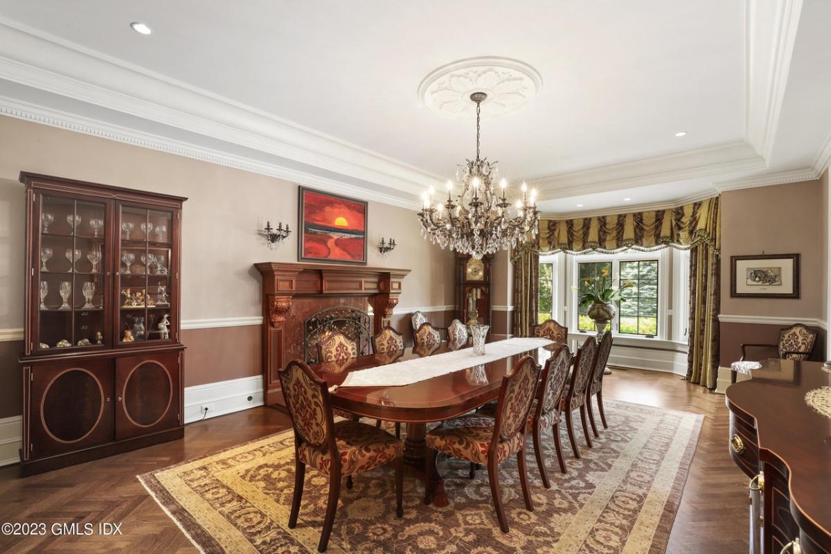 Dining room with a large wood table and a chandelier.