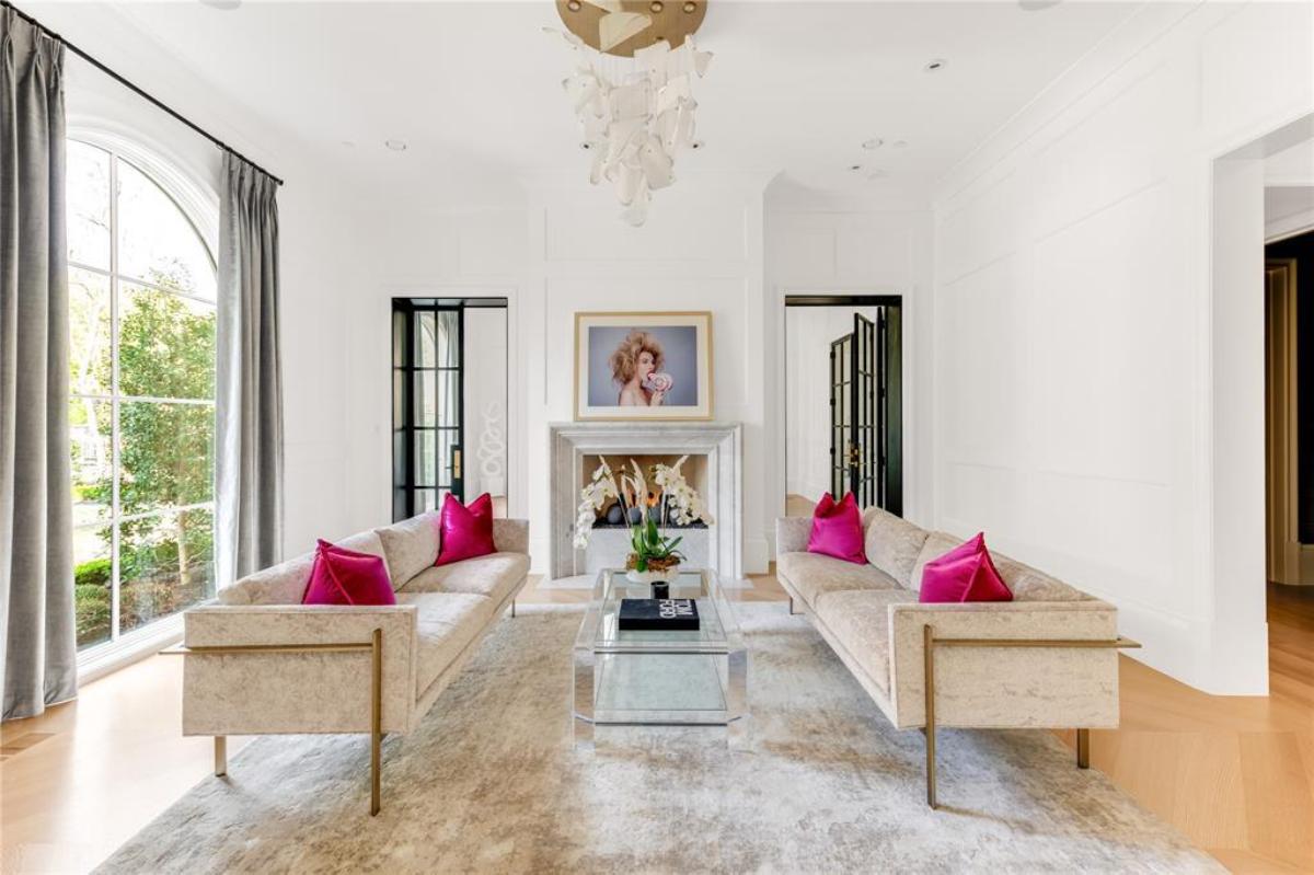 Living room with sofas, glass windows and a fireplace.
