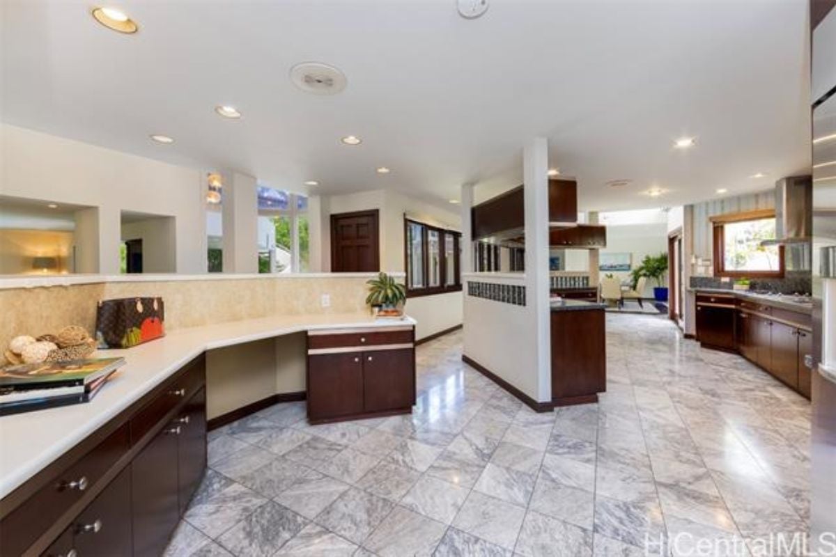 A kitchen with a tiled floor, countertops, and cabinets.