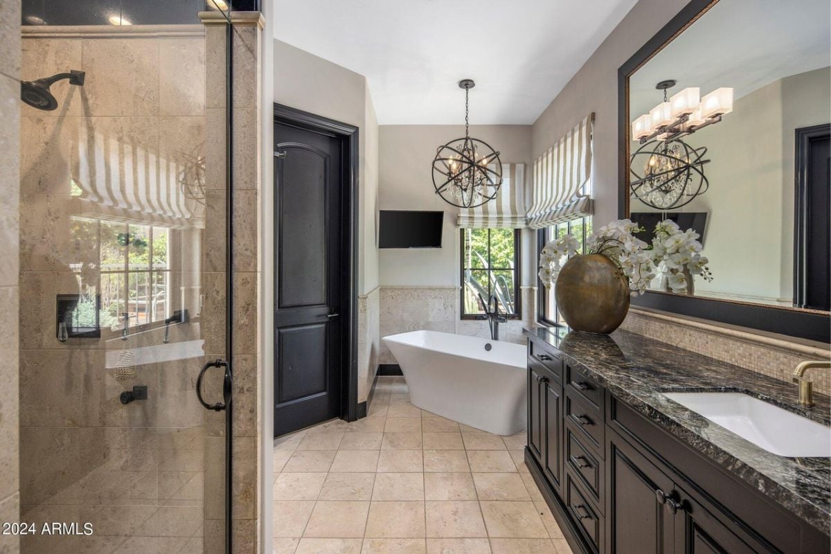A bathroom with a countertop, sink, mirror, vase, cabinets, shower room, and bathtub.