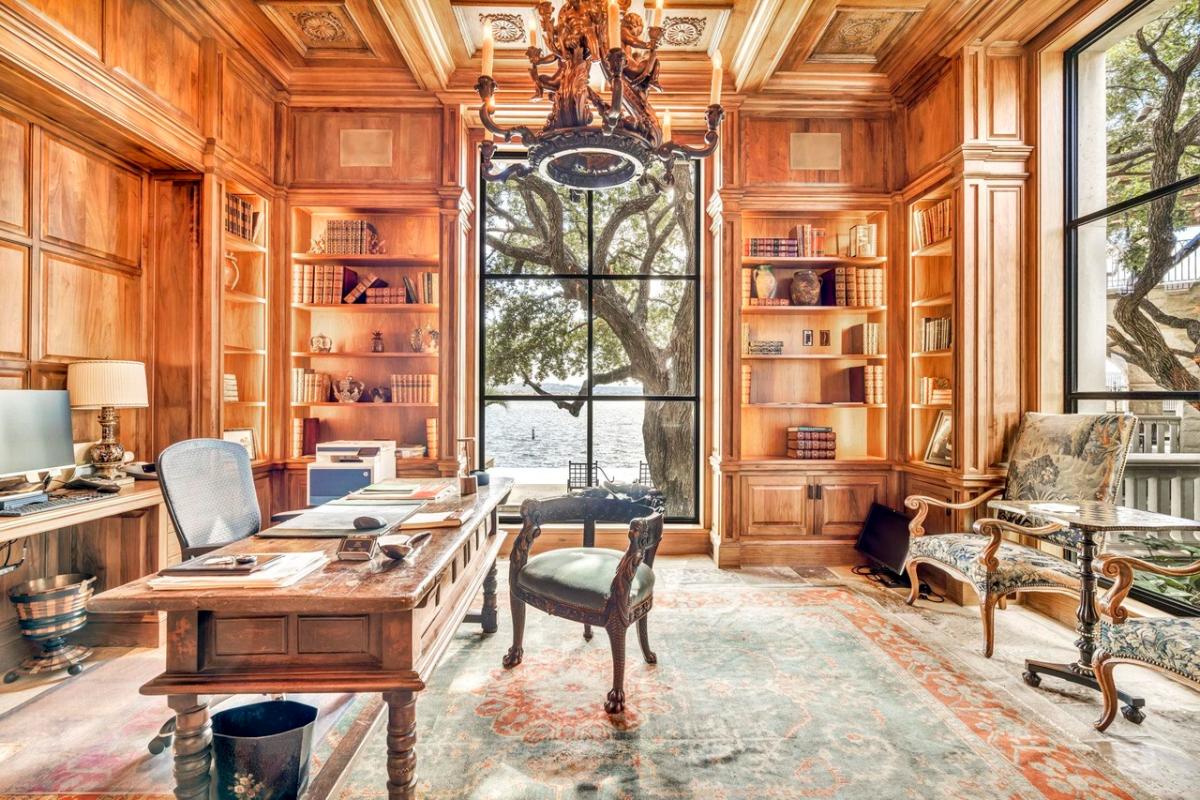Home office with glass walls and wood ceiling beams.