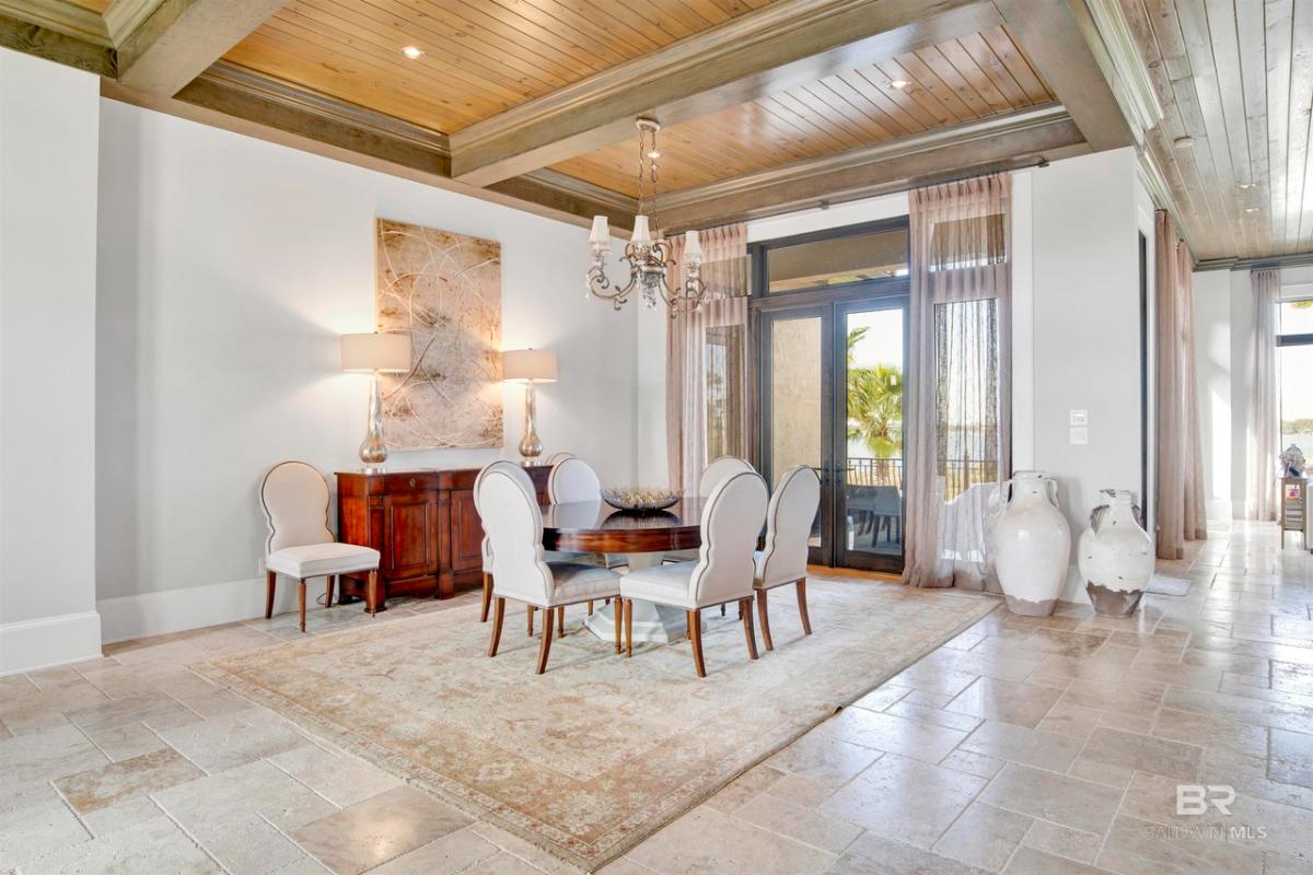Dining room with a chandelier and open beam ceiling.
