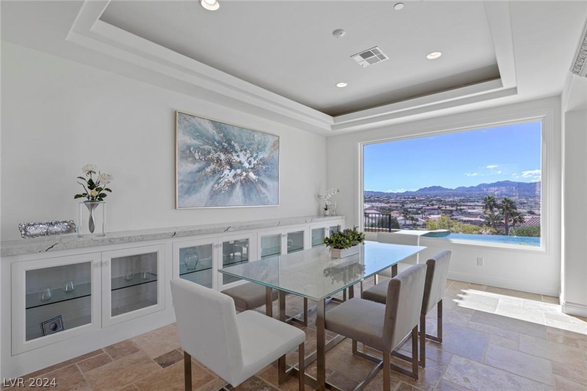 Dining room with glass table and glass windows.