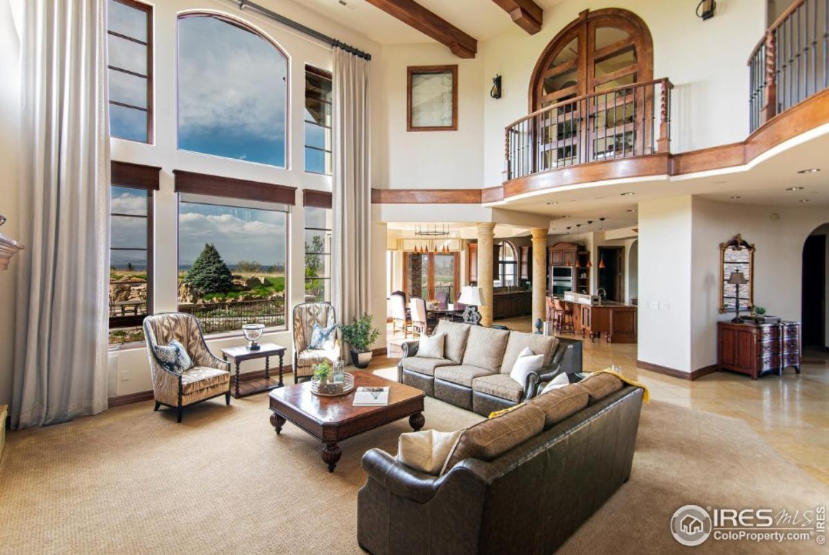 Living room with tables, chairs, couches and large glass windows.