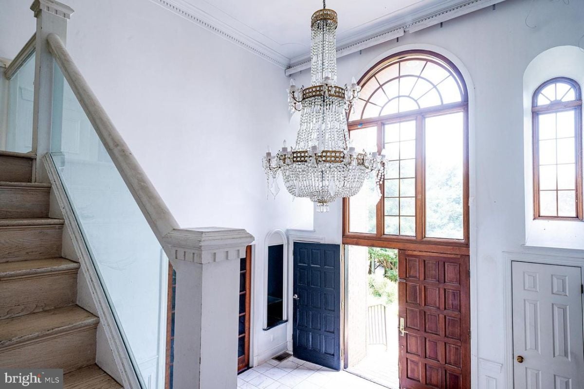 A foyer with a chandelier, window, and staircase.