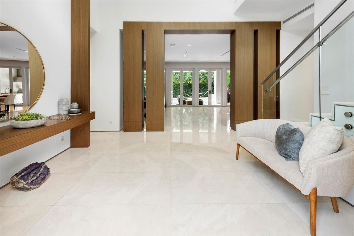 A seating area with a tiled floor, couch, and mirror.