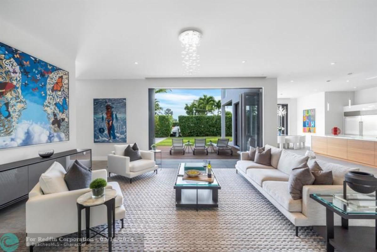 Living room with a chandelier, tables and chairs.