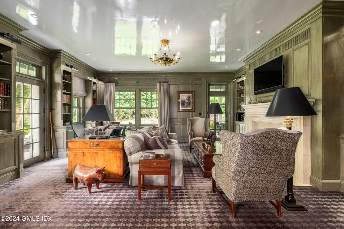 Home office with carpet flooring, tables and sofas.