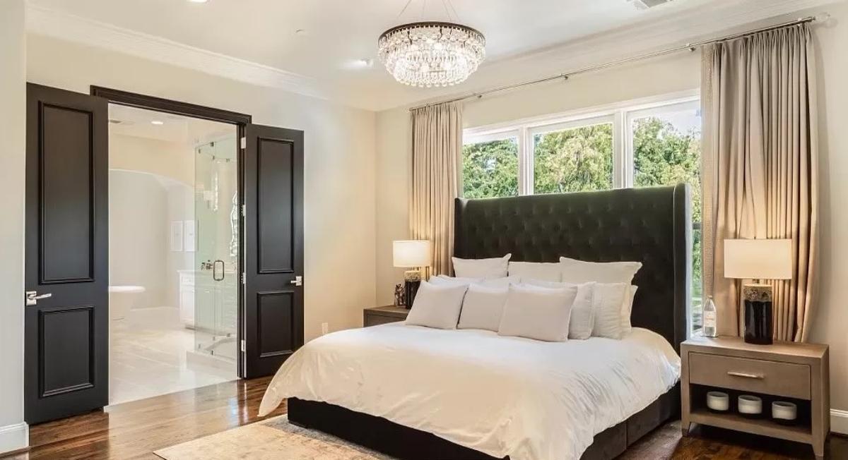 Bedroom with a chandelier and glass windows.