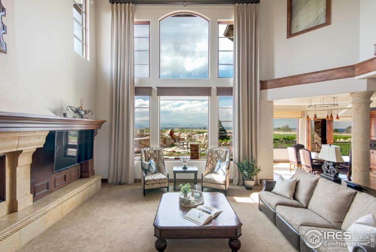 Living room with tables, chairs, couches and large glass windows.