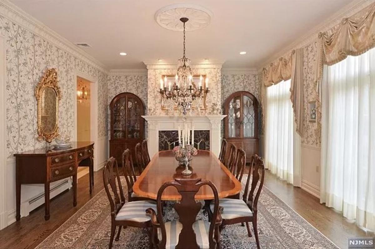 Dining room with a large wooden table and a chandelier.