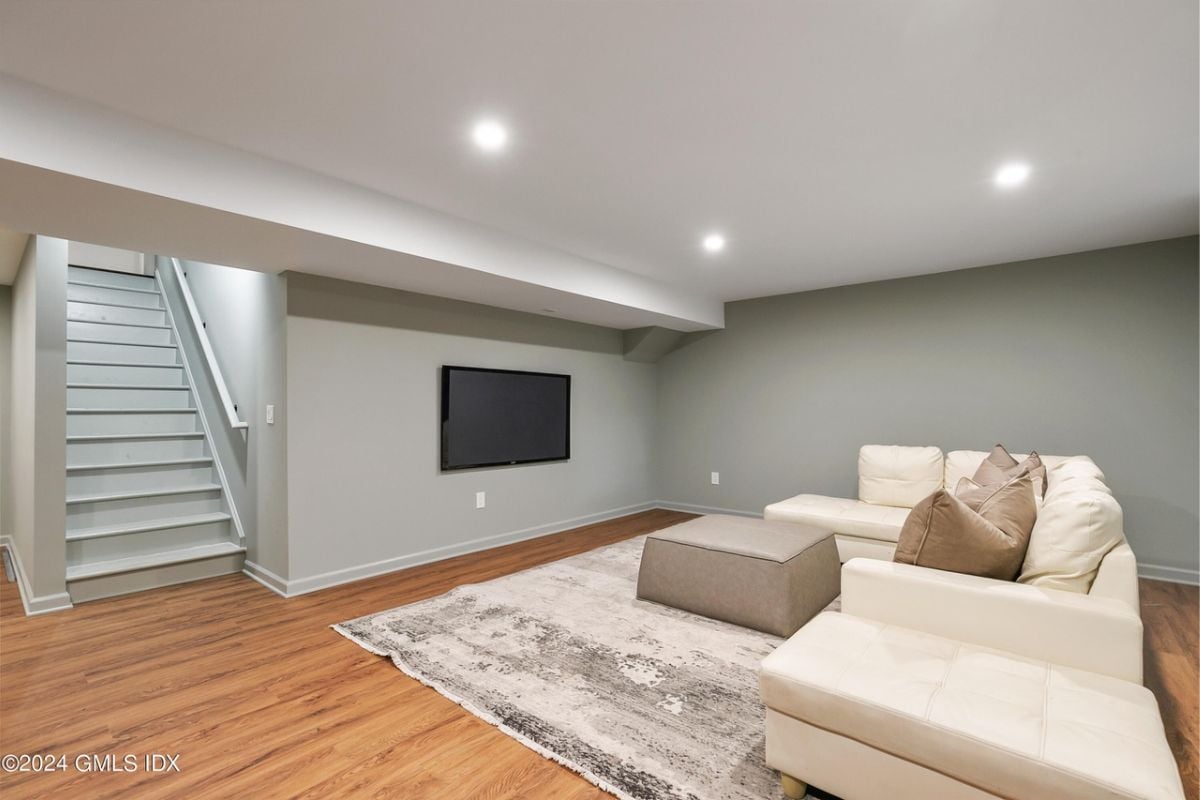 A lounge with a TV, a white couch, and a coffee table.