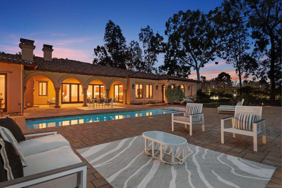 A brick patio with chairs and a coffee table.